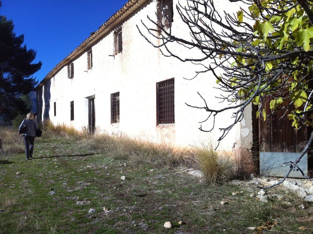 Fachada encalada de una casa de campo antigua con rejas
